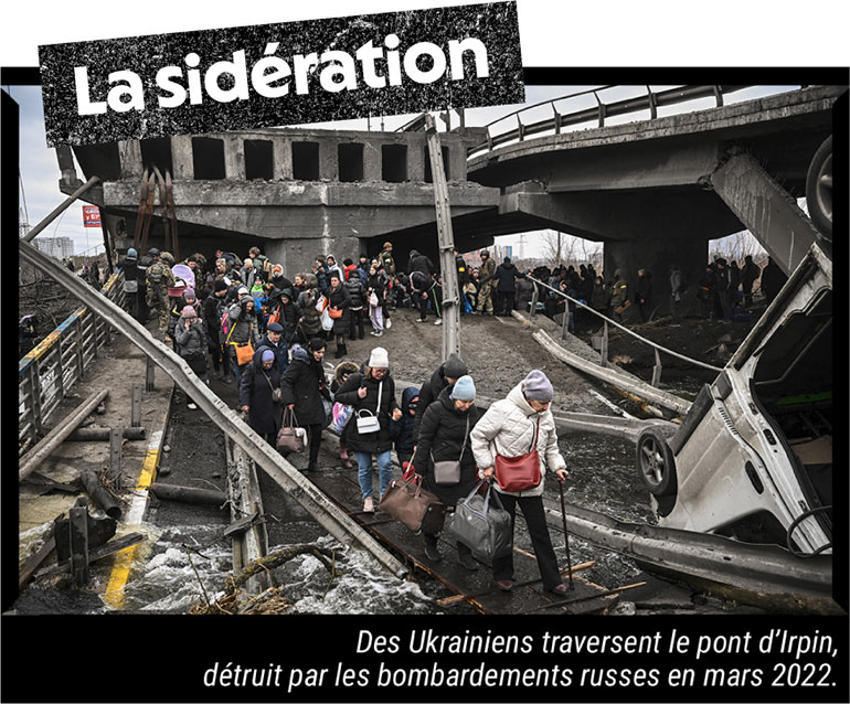 Des Ukrainiens traversent le pont d'Irpin, détruit par les bombardements russes en mars 2022.