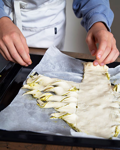 Recette de Noël : le sapin au pesto de Circé. Découpe dans la pâte de la forme d’un sapin avec des branches.