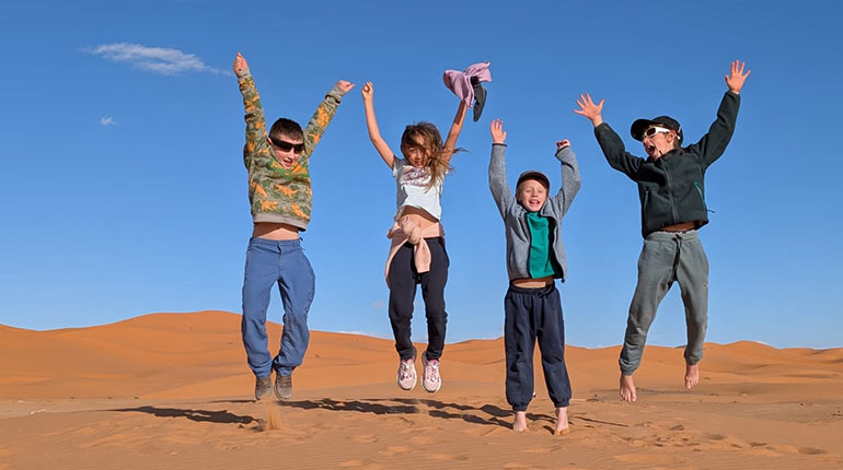 Voyage au Maroc - Des enfants sautent dans le désert