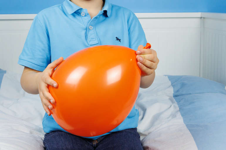 Photo d'un garçon tenant un ballon dans ses mains.