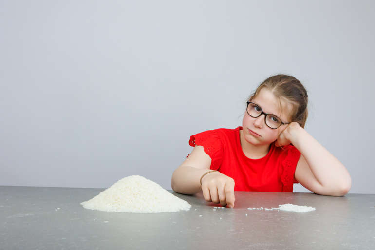 Photo petite fille comptant le nombre de grains de riz.