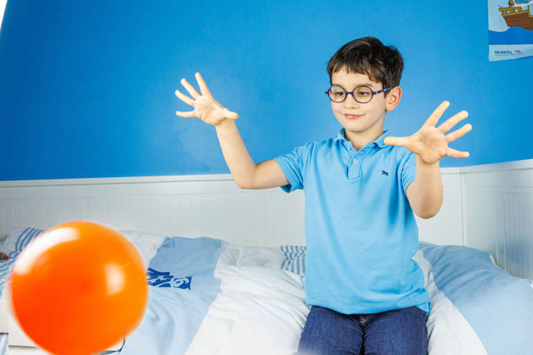 le petit garçon lance le ballon.
